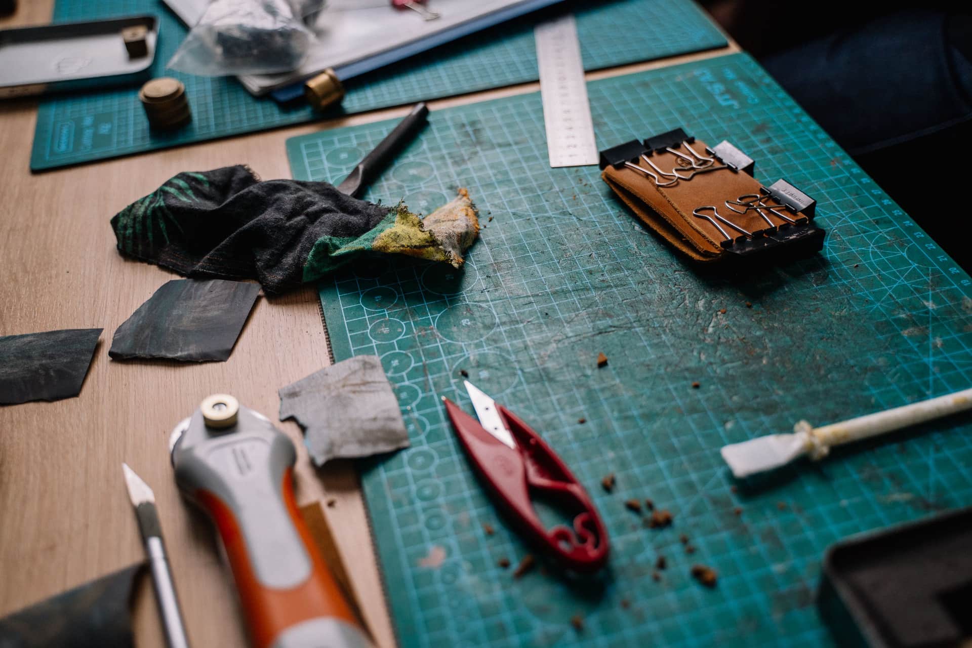 A craft workbench with a cutting machine, vinyl and hand tools